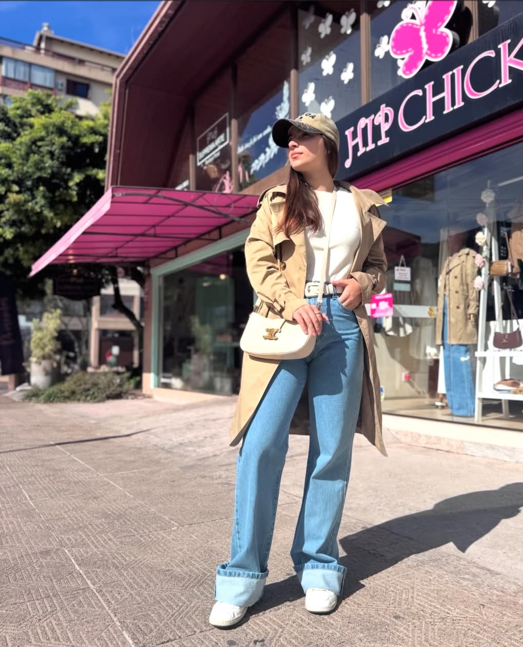 Look Hip Chick com trench coat, jeans e bolsa clara